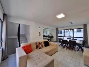 a living room with a couch and a dining room at Casa a 100 metros da praia de Balneário Camboriú in Balneário Camboriú