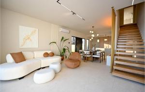 a living room with a white couch and a dining room at Nice Home In Makarska With Jacuzzi in Makarska