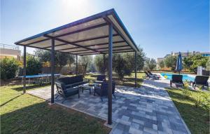 ein Pavillon mit Stühlen und einem Tisch in einem Hof in der Unterkunft Cozy Home In Vodnjan With Wifi in Vodnjan + 23 Fotos