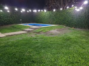 a backyard at night with a swimming pool and lights at Malepa in Salta