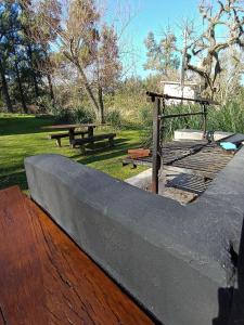 a picnic table and benches in a park at Quinta isleña Monte Blanco - Domingos Checkout 17 hs in Tigre