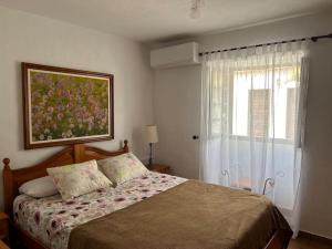 a bedroom with a bed with a painting on the wall at Villa feliz casa Los Abuelos B in Tijarafe