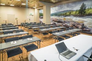 a classroom with tables and chairs and a laptop on the wall at Lapland Hotels Oulu in Oulu