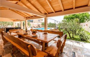 a wooden table and chairs on a patio at 7 Bedroom Awesome Home In Polaca in Polača