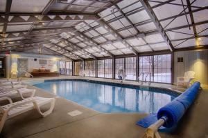 une grande piscine avec des chaises et une piscine dans l'établissement Sun & Ski Inn and Suites, à Stowe