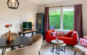 a living room with a red couch and a table at Awesome Home In Heinkenszand With Wifi in Heinkensand