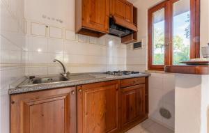 a kitchen with wooden cabinets and a sink at Poiana in Orbetello