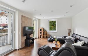ein Wohnzimmer mit einer schwarzen Couch und einem Fernseher in der Unterkunft Suite Am Bleek Eg in Wernigerode
