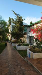 a walkway in front of a building with flowers at Casa 2 pisos Para 5 personas toda equipada in Colonia del Sacramento