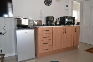 Una cocina con un refrigerador blanco y un microondas. en 7 Woodmead Suites, en Johannesburgo