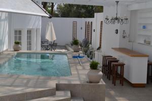 una piscina en un patio con sillas y mesa en 7 Woodmead Suites, en Johannesburgo