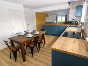 a kitchen with a wooden table and some chairs at Lobster Cottage in Saundersfoot +20 photos