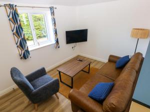 a living room with a couch and two chairs at Lobster Cottage in Saundersfoot