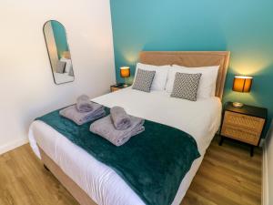 a bedroom with a bed with towels on it at Lobster Cottage in Saundersfoot