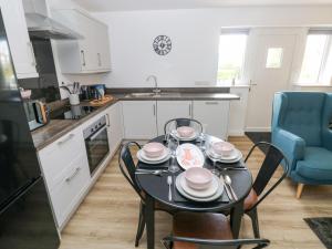 a kitchen with a table with dishes on it at Oyster Cottage in Saundersfoot +20 photos