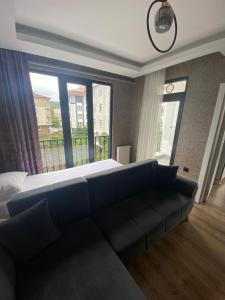 a bedroom with a couch and a large window at SEZGİN KARGI - Günübirlik Turizm Evleri in Akçatepe