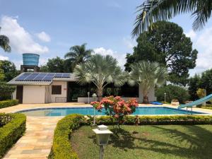 a house with a swimming pool with a solar roof at Chácara 5 suítes e piscina em Cabreúva in Cabreúva