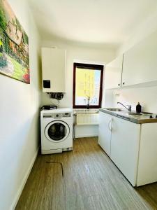 uma cozinha com máquina de lavar e pia em Beautiful 4BR Apt for up to 12P 10 Min to FAC Platz em Viena