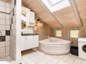 a bathroom with a tub and a washing machine at 4 star holiday home in Nysted in Nysted +46 photos