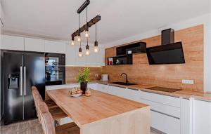 una cucina con un tavolo di legno e un frigorifero di Awesome Home In Kuciste With Wifi a Kučište