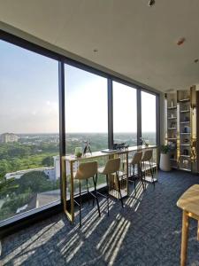 d'un bureau avec une table, des chaises et de grandes fenêtres. dans l'établissement The Astra Sky River 2 bedrooms, à Chiang Mai