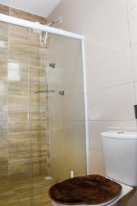 ein Bad mit einem WC und einer Glasdusche in der Unterkunft Casa Da Onda in Tamandaré