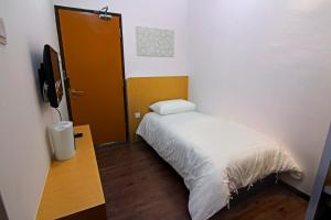 a small bedroom with a bed and a television at Thanks Hotel in Parit Buntar