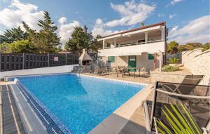 a swimming pool in front of a house at Lovely Home In Mandre With Kitchen in Mandre