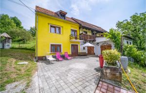 an exterior view of a yellow house with pink chairs at Awesome Home In Prodin Dol in Ivančići +18 photos