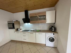 a kitchen with a sink and a washing machine at Ferienwohnungen Schiffmann in Pressath