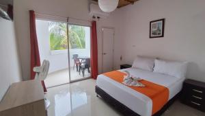a bedroom with a bed and a large window at Hotel campestre París soleil in Mariquita