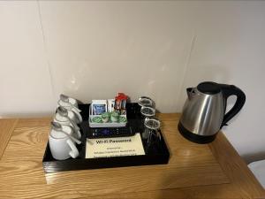 a tray with a coffee pot and a tea kettle on a table at Whisky Capital Inn in Dufftown