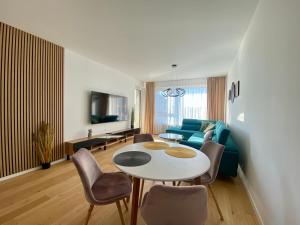 a living room with a table and chairs and a couch at Danubius Apartments in Bratislava