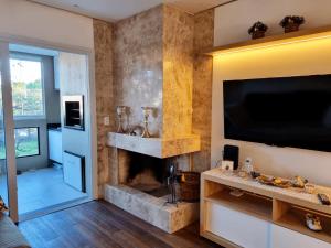 a living room with a fireplace and a television at Belluno Boulevard Canela in Canela