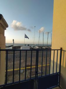 a balcony with a view of the beach and boats at Villa de l'epi Grandcamp Maisy in Grandcamp-Maisy