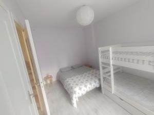 a white bedroom with a bunk bed and a crib at Villa de l'epi Grandcamp Maisy in Grandcamp-Maisy