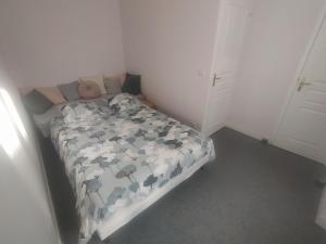 a bedroom with a bed with a comforter on it at Villa de l'epi Grandcamp Maisy in Grandcamp-Maisy