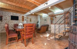 ein Wohnzimmer mit Tisch und Stühlen und einer Treppe in der Unterkunft 2 Bedroom Nice Home In Nevest in Unešić