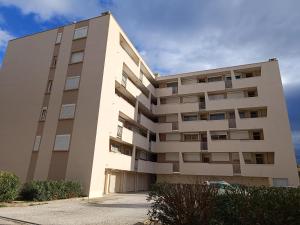 ein hohes Gebäude mit einem davor geparkt in der Unterkunft Entre le port et le secteur Maillol spacieux T3 tout confort - 6CAL503 in Saint Cyprien Plage