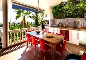 eine Küche mit einem Tisch und Stühlen auf dem Balkon in der Unterkunft Villa Gemma Celebration Haven in Málaga