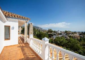 einen Balkon mit weißem Geländer und Stadtblick in der Unterkunft Villa Gemma Celebration Haven in Málaga