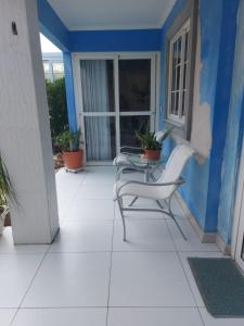 a patio with two chairs and a table on a house at Fantástica Casa 03 Quartos nas belíssimas Praias do Flamengo in Salvador