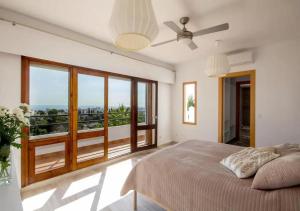 ein Schlafzimmer mit einem Bett und einem großen Fenster in der Unterkunft Villa Gemma Celebration Haven in Málaga