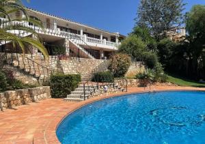 ein großes Schwimmbad vor einem Gebäude in der Unterkunft Villa Gemma Celebration Haven in Málaga