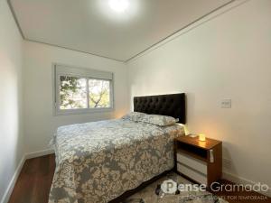 a bedroom with a bed and a window at Belluno Boulevard Canela in Canela