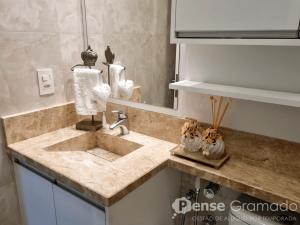a kitchen counter with a sink and a mirror at Belluno Boulevard Canela in Canela +7 photos