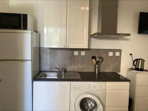 a kitchen with a white refrigerator and a washing machine at Villa Thyziri in Roquefort-les-Pins +10 photos