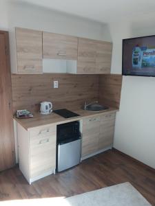 a small kitchen with wooden cabinets and a sink at Apartmán KATY in Rajecké Teplice