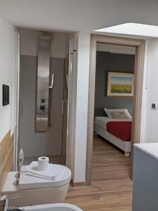 a bathroom with a toilet and a bed at Attico al Gallitello in Potenza