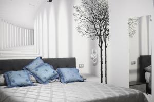 una camera da letto con un letto con cuscini blu e un albero di Giorgina'S Suite a Montecorvino Pugliano